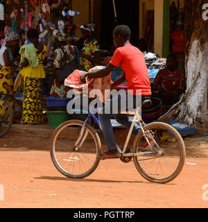 CANCHUNGO, GUINEA BISSAU - 3 Maggio 2017: locale non identificato il ragazzo corse in bicicletta in centro di Canchungo, una delle principali città del paese Foto Stock