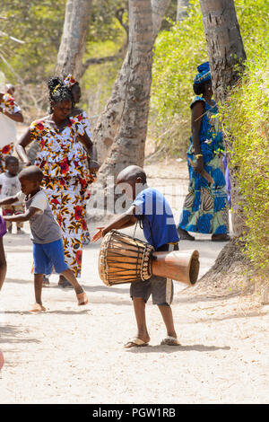 KASCHOUANE, SENEGAL - Apr 29, 2017: Unidentified Diola little boy gioca sui tamburi in Kaschouane village. Diolas sono il gruppo etnico predominante nel Foto Stock