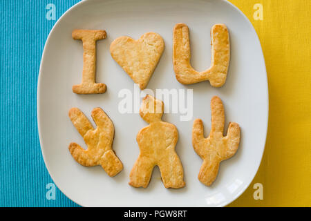 Biscotti fatti in casa ti amo su giallo e blu Foto Stock