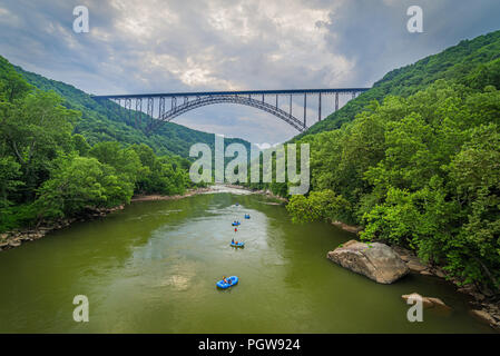 Acqua bianco rafters flottazione verso il basso il nuovo River Gorge in West Virginia sotto il grande arco in acciaio ponte. Foto Stock