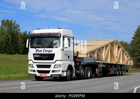 UURAINEN, Finlandia - 25 agosto 2018: Bianco Uomo TGX 26.480 semi carrello di azzurro carico Oy trasporta capriata sul rimorchio piatto lungo l'autostrada. Foto Stock