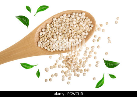 Quinoa rossa sementi nel cucchiaio di legno decorato con foglie verdi isolati su sfondo bianco. Vista superiore Foto Stock