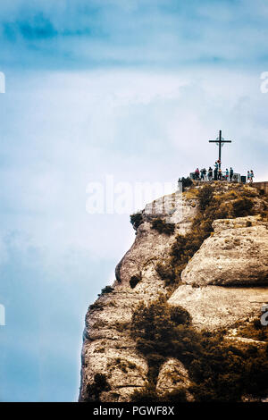Saint Michael's cross in Montserrat, Barcellona contro un cielo nuvoloso. Destinazione di viaggio e simbolo religioso con vuoto lo spazio di copia per l'editor di testo. Foto Stock