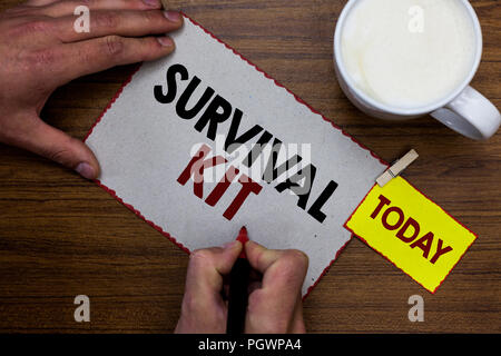 Mano concettuale che mostra la scrittura del Kit di sopravvivenza. Business photo testo attrezzature di emergenza la raccolta di elementi per aiutare qualcuno a Uomo con notebook marcatore Foto Stock