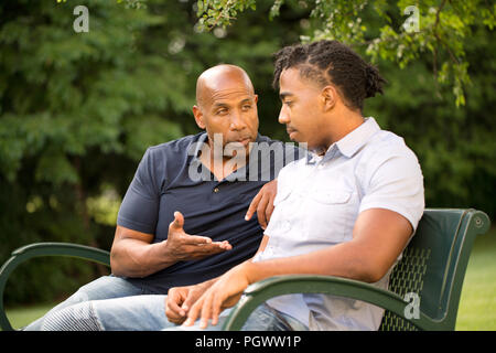 Uomo maturo mentoring e dare consigli ad un uomo giovane. Foto Stock