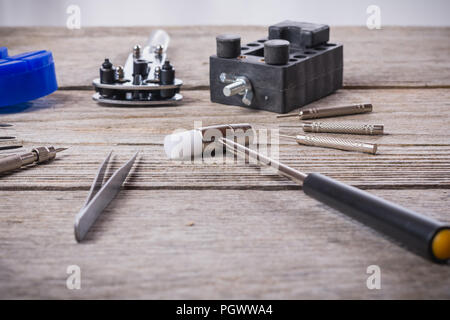 Set di strumenti orologiaio isolato su una rozza tavola di legno vicino fino Foto Stock