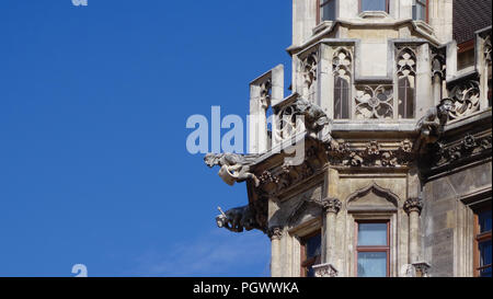 Dettaglio della pietra religiosa gargoyles su una torre a Monaco di Baviera, Germania Foto Stock