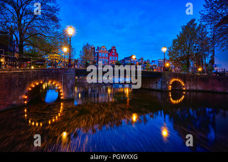 Amterdam canal, il ponte e le case medievali di sera Foto Stock