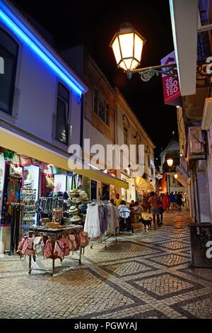 Via dello shopping nella città vecchia di notte con turisti che si godono la impostazione, Albufeira, Portogallo, Europa. Foto Stock