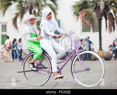 Giovani ragazze indonesiane in sella ad una bicicletta in Giacarta Fatahillah Square. Foto Stock