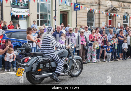 Un uomo anziano in una tuta hooped e in sella a una moto l'annuale Street Parade presso il Barnard Castle si incontrano a Barnard Castle,l'Inghilterra,UK Foto Stock