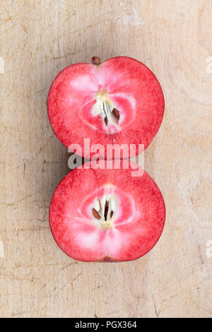 Malus domestica 'Tickled pink' / Baya Marisa. Raccolte Apple 'Tickled rosa'. Tagliato a metà per mostrare la carne rossa Foto Stock