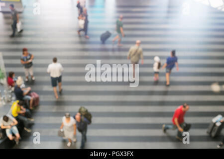 Abstract offuscata la gente a piedi con i bagagli in aeroporto o stazione ferroviaria area. In arrivo e in partenza passeggeri. Foto Stock