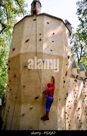 Spiderman su un muro di roccia da scalare al Renaissance festival del Maryland Foto Stock