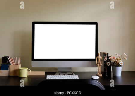 Area di lavoro con un display di computer e strumenti di office su tavola nera. Computer desktop isolato sullo schermo. Moderno banco creative con fiore . Vista frontale. Foto Stock