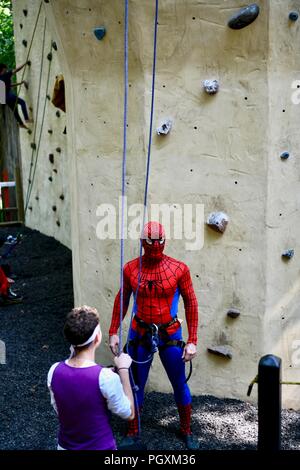 Spiderman su un muro di roccia da scalare al Renaissance festival del Maryland Foto Stock