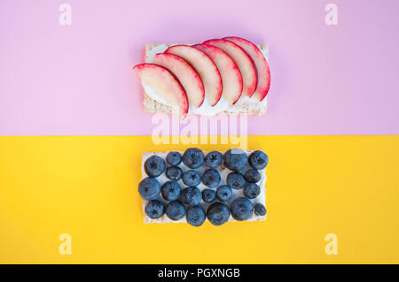 Deliziosi panini sani sul giallo e rosa sfondo. Cibo sano concetto. Foto Stock