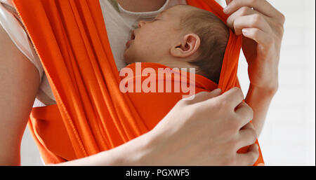 Donna che trasportano nel neonato bimbo si aggrappano Foto Stock