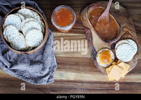 Vista dall'alto di acqua cracker e formaggio cheddar artigianale e salate vaniglia melone marmellata. Immagine ripresa dal di sopra. Foto Stock