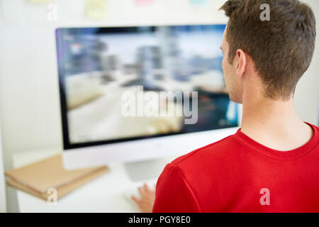 Fotografia designer guardando l'immagine sullo schermo del computer mentre il ritocco dal luogo di lavoro Foto Stock