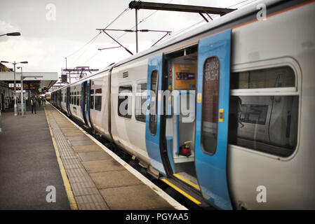 Treno vuoto in attesa sulla piattaforma a Cambridge station su un pomeriggio nuvoloso Foto Stock