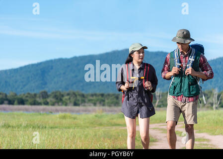 Due persone che camminano sul percorso nel campo di prato. Maschio e femmina traveler guardando attrazione punto di vista. Coppie di avventura all'aperto insieme. Persone Foto Stock