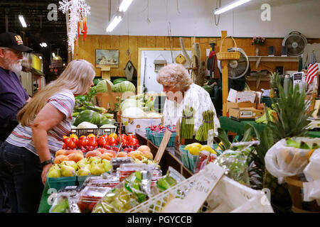 Gilbertsville, Pennsylvania, USA - 24 agosto 2018: I clienti acquistano verdure fresche presso uno stand di prodotti all'interno del mercato agricolo di Zerns. Foto Stock