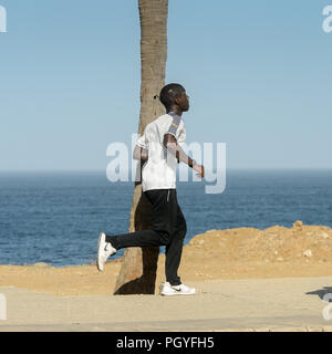DAKAR, Senegal - Apr 23, 2017: Non identificato uomo senegalese corre sulla spiaggia di Dakar, la capitale e la principale città del Senegal Foto Stock