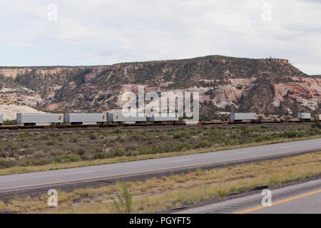 Contenitori UPS su auto e treno che viaggia attraverso il deserto rurale - Arizona USA Foto Stock