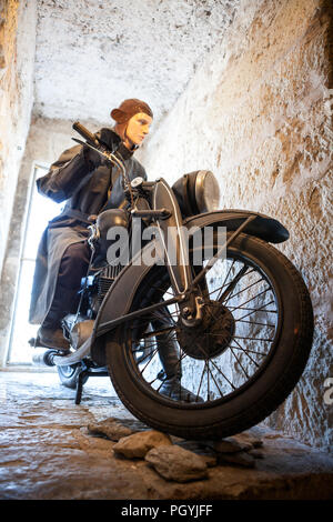 KURESSAARE, ESTONIA - CIRCA MAR, 2018: Antico motociclo militare con il motociclista figura come driver. Fiore è in Saaremaa museum di Kuressaare C Foto Stock