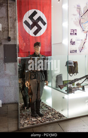 KURESSAARE, ESTONIA - CIRCA MAR, 2018: soldato tedesco con bandiera nazista. Sala del nord-est dell ala del castello offre una panoramica delle battaglie combattute su Sa Foto Stock