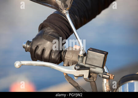Braccio per motociclisti in guanto nero tiene a manopola acceleratore, vista ravvicinata Foto Stock