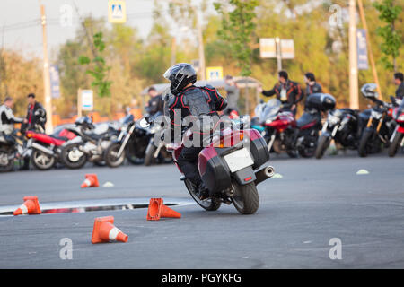 Conducente del motociclo in sella moto su piazza urbano utilizzando come autodromo, vista posteriore Foto Stock