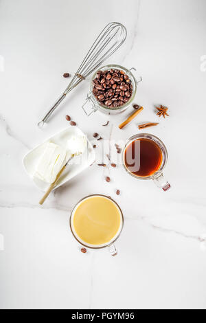Alla moda di ketogenic la dieta alimentare, Bulletproof caffè con latte e burro, il marmo bianco di sfondo spazio copia vista superiore Foto Stock