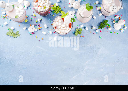 Variazioni di amaro da latte e cioccolata calda con divertenti marshmallow in forma pupazzi di neve, orsi bianchi, con dolci e foglie decorative, azzurro backgr Foto Stock