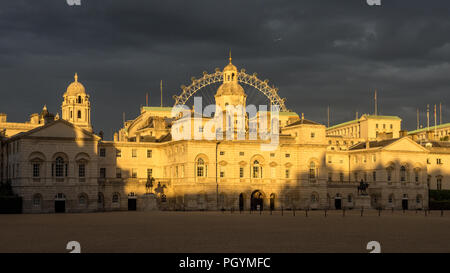 Londra, Inghilterra - 5 Agosto 2015: sera la luce del sole cade su edifici governativi di Whitehall e il London Eye oltre la sfilata delle Guardie a Cavallo di una messa a terra Foto Stock