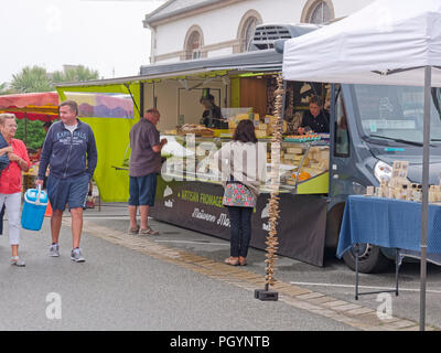 Landeda, Francia - 14 agosto 2018: a Landeda street market persone acquistano formaggi dal Fromage stallo. Altre persone a fare una passeggiata da la sta Foto Stock