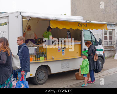 Landeda, Francia - 14 agosto 2018: su un grigio e umido al mattino Landeda street market una Madonna e Bambino stand oltre il caldo crepes van. Foto Stock