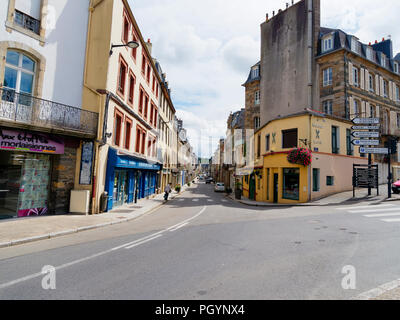 Morlaix, Francia - 10 agosto 2018: Una tranquilla giornata sulla Rue de Paris a Morlaix. Una signora con un bastone da passeggio fa il suo modo attraverso la strada. Foto Stock