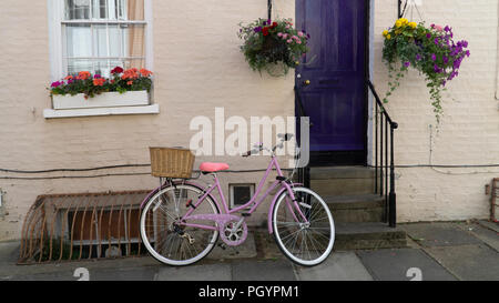 Viola moto parcheggiata fuori casa di Cambridge con cassetta per fiori e cesto pensile Foto Stock
