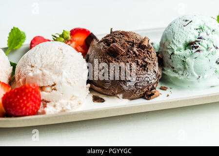 La selezione di diversi ice cream scoop come la menta, cioccolato e fragola sulla targhetta ovale Foto Stock