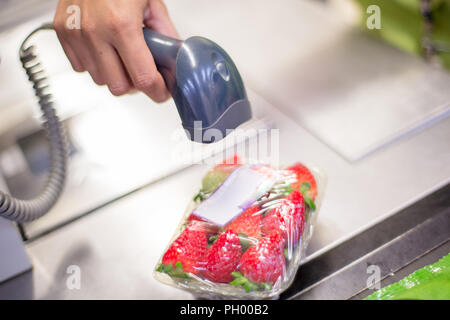 Lettore di codice a barre la lettura del codice di un pacchetto di fragole sulla cassa in un supermercato Foto Stock
