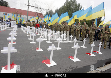 Kiev, Ucraina. Il 29 agosto, 2018. Combattenti ucraini sorge in prossimità di incroci con portrets di ucciso soldati ucraini, che erano stati persi in combattimenti nei pressi di Ilovaysk città quattro anni fa, durante una manifestazione di protesta di fronte l'Ambasciata russa a Kiev in Ucraina, il 29 agosto 2018. Gli ucraini riuniti in memoria di perdita di soldati ucraini, marcatura marcatura del quarto anniversario della lotta in Ilovaysk. Credito: ZUMA Press, Inc./Alamy Live News Foto Stock