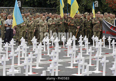 Kiev, Ucraina. Il 29 agosto, 2018. Combattenti ucraino canta l inno nazionale come appaiono sul portrets di ucciso soldati ukrainiens collocato su croci, che erano stati persi in combattimenti nei pressi di Ilovaysk città quattro anni fa, durante una manifestazione di protesta di fronte l'Ambasciata russa a Kiev in Ucraina, il 29 agosto 2018. Credito: ZUMA Press, Inc./Alamy Live News Foto Stock