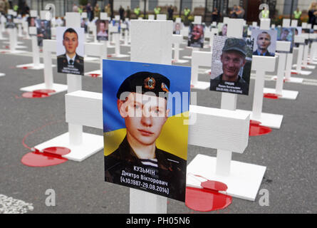 Kiev, Ucraina. Il 29 agosto, 2018. Portrets di ucciso soldati ukrainiens collocato su croci, che erano stati persi in combattimenti nei pressi di Ilovaysk città quattro anni fa, sono visti durante una manifestazione di protesta di fronte l'Ambasciata russa a Kiev in Ucraina, il 29 agosto 2018. Gli ucraini riuniti in memoria di perdita di soldati ucraini, marcatura marcatura del quarto anniversario della lotta in Ilovaysk. Credito: ZUMA Press, Inc./Alamy Live News Foto Stock