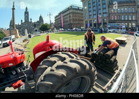 Glasgow, Scotland, Regno Unito. 29 Agosto, 2018. Ora di pranzo gli ospiti sono stati trattati per un po' di storia vivente come un classico rosso 1964 Massey Ferguson 35X trattore è apparso nella città del George Square. La gente del posto e i turisti hanno guardato come il tappeto erboso che è stato sollevato per il recente Campionato Europeo accogliente centro è stato sostituito. Il modello Sport insoliti ruote doppie per aumentare la trazione e è stata modificata dal proprietario fiero nella foto. Gerard Ferry/Alamy news Foto Stock