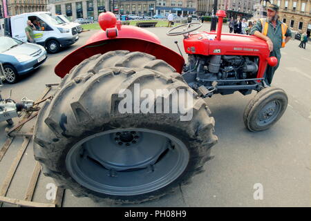 Glasgow, Scotland, Regno Unito. 29 Agosto, 2018. Ora di pranzo gli ospiti sono stati trattati per un po' di storia vivente come un classico rosso 1964 Massey Ferguson 35X trattore è apparso nella città del George Square. La gente del posto e i turisti hanno guardato come il tappeto erboso che è stato sollevato per il recente Campionato Europeo accogliente centro è stato sostituito. Il modello Sport insoliti ruote doppie per aumentare la trazione e è stata modificata dal proprietario fiero nella foto. Gerard Ferry/Alamy news Foto Stock