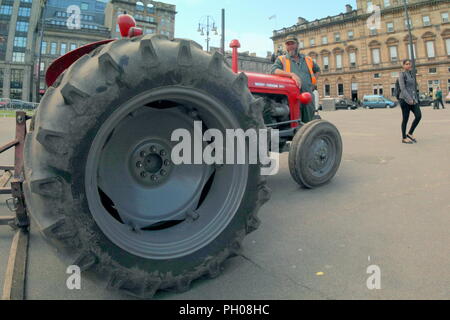 Glasgow, Scotland, Regno Unito. 29 Agosto, 2018. Ora di pranzo gli ospiti sono stati trattati per un po' di storia vivente come un classico rosso 1964 Massey Ferguson 35X trattore è apparso nella città del George Square. La gente del posto e i turisti hanno guardato come il tappeto erboso che è stato sollevato per il recente Campionato Europeo accogliente centro è stato sostituito. Il modello Sport insoliti ruote doppie per aumentare la trazione e è stata modificata dal proprietario fiero nella foto. Gerard Ferry/Alamy news Foto Stock