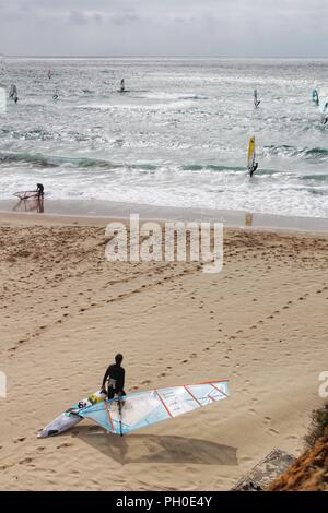 Surfisti a Guincho spiaggia sotto il cielo nuvoloso nella primavera del Portogallo Foto Stock