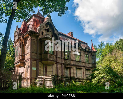 A due piani edificio di legno costruito nel 1902 con torrette, finestre a baia, camini su un tetto dello stagno, con ampia mansarda windows Shuvalov nel Parco di San Petersbu Foto Stock